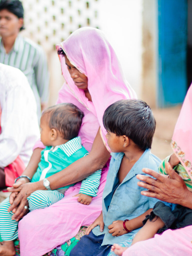 Members of pastor *Bahula's church pray at an outdoor worship service.